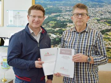 Vagner Cielo, presidente da XI Femaçã, entrega relatório para o prefeito da cidade de Veranópolis, Waldemar De Carli.